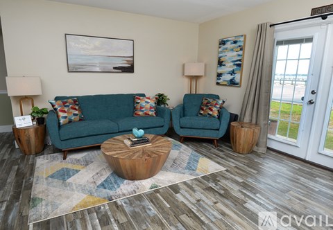 A living room with a blue couch and a wooden coffee table.