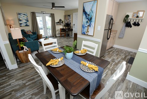 A dining room with a wooden table set for two.