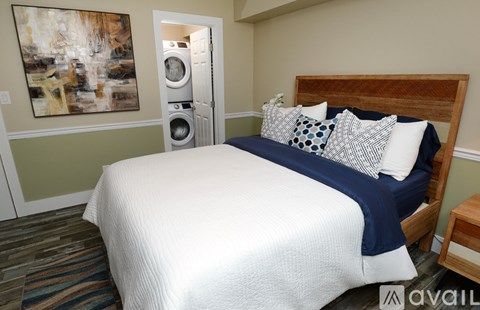 A bedroom with a large bed and a painting on the wall.