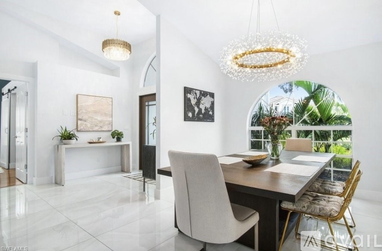 A modern dining room with a white table and chairs.