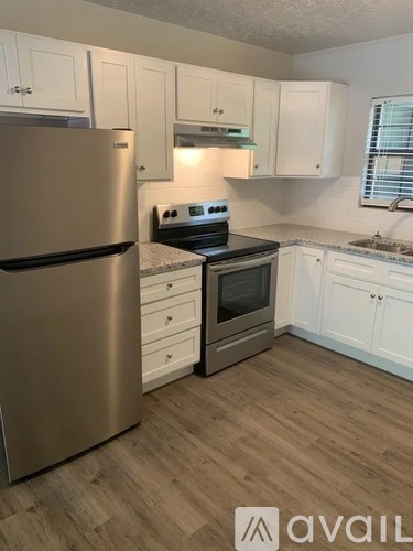 A kitchen with a stainless steel refrigerator and a stove top oven.