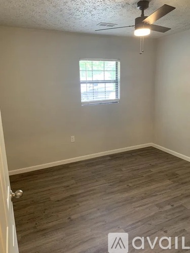 A room with a ceiling fan and a window.