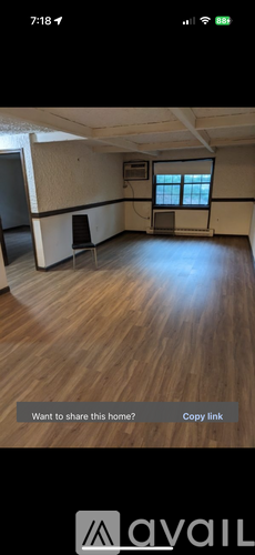 A room with wooden flooring and a window.