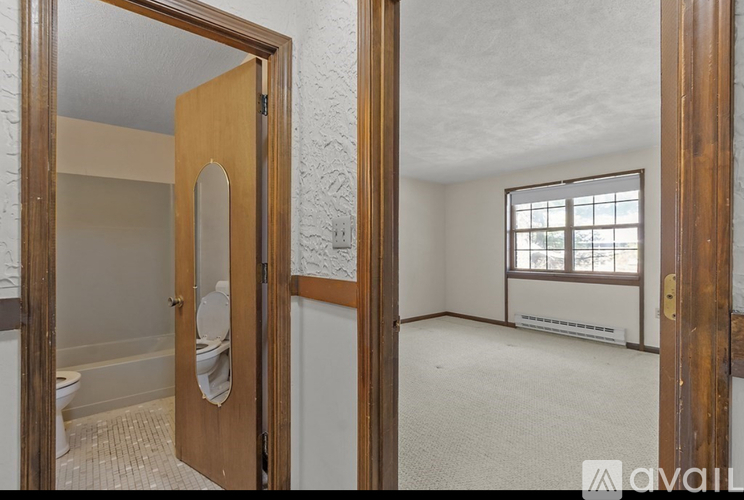 A bathroom with a toilet and a window is shown.