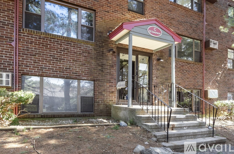 A brick building with a red and white awning and a glass door.