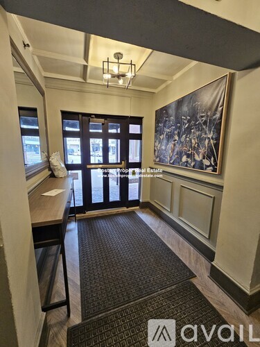 A room with a large window and a painting on the wall.