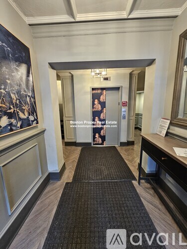 A hallway with a carpeted floor and a poster on the wall.
