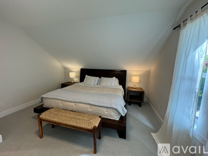 A bedroom with a large bed and a bench in front of it.