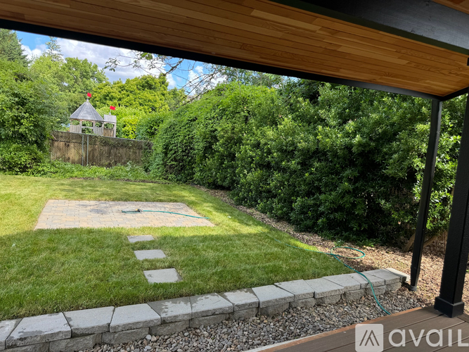 A backyard with a wooden deck and a small gazebo.