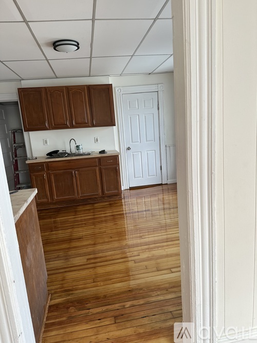 A kitchen with wooden floors and white walls.
