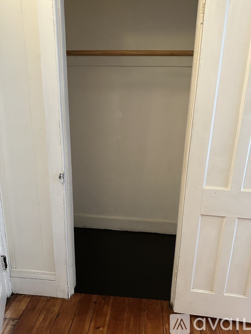 A white door with a black mat on the floor.