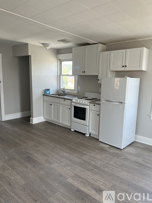 A kitchen with white appliances and cabinets.
