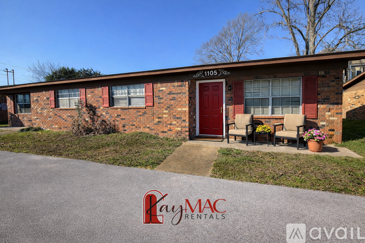 A house with a red brick exterior and a brown roof is for sale.