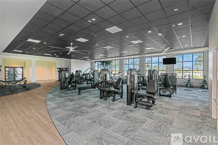A gym with a variety of equipment including treadmills, weights, and exercise machines.