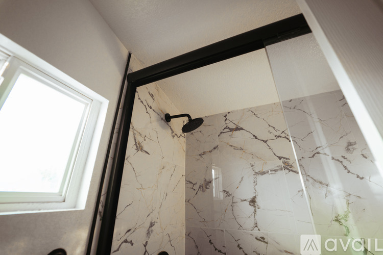A bathroom with marble tiles and a window.