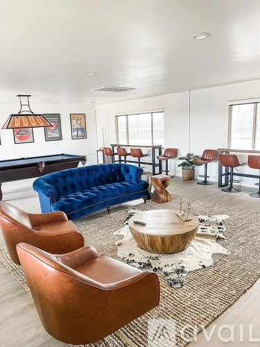 A living room with a pool table and a blue sofa.