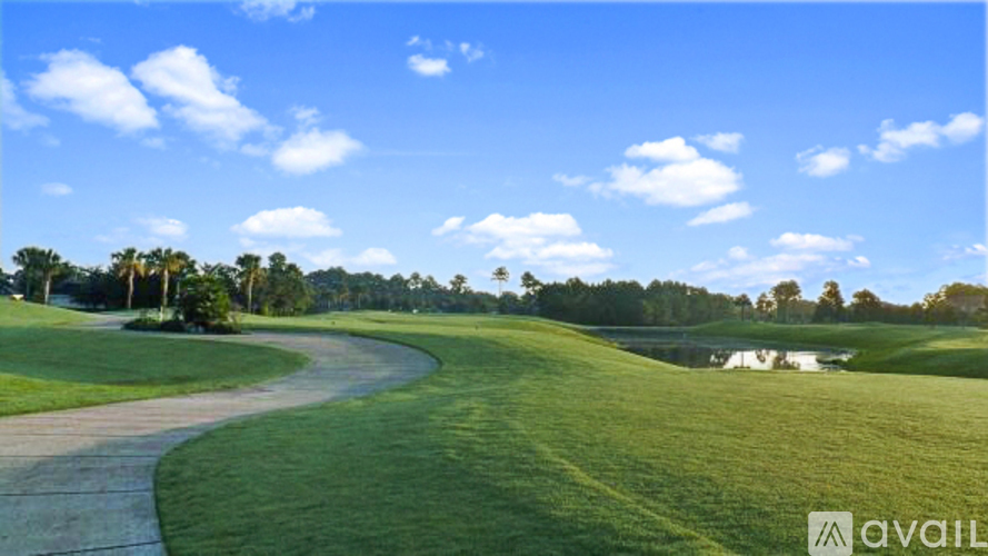 A golf course with a clear blue sky and a winding path.