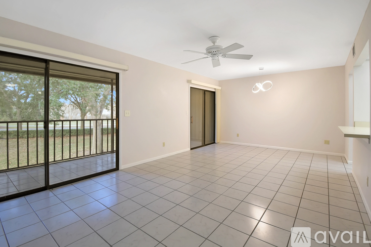 A spacious room with a sliding glass door leading to a balcony.