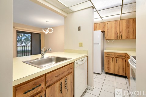 A kitchen with wooden cabinets and a white fridge.