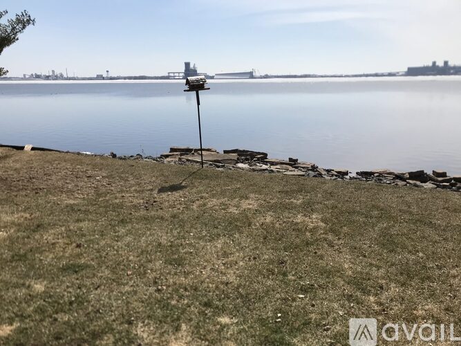 A weather station is located on a grassy area near a body of water.