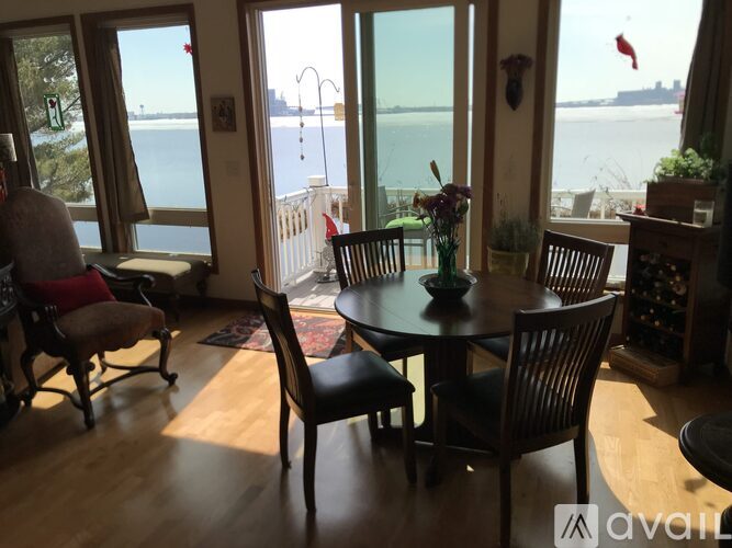 A dining room with a table and chairs overlooking a body of water.