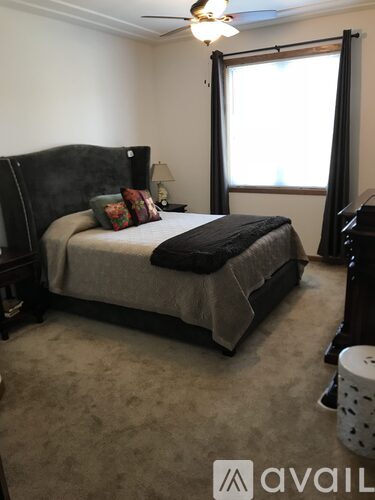 A bedroom with a large bed and a ceiling fan.