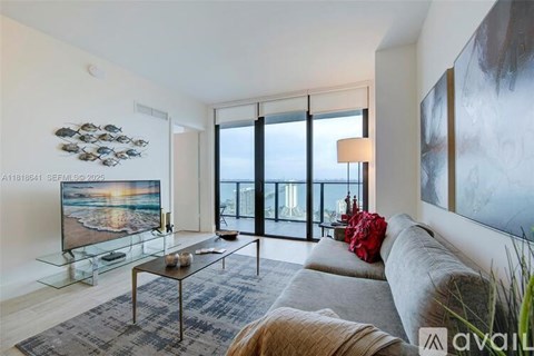 A modern living room with a flat screen TV and a glass coffee table.