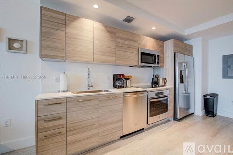 A modern kitchen with wooden cabinets and stainless steel appliances.
