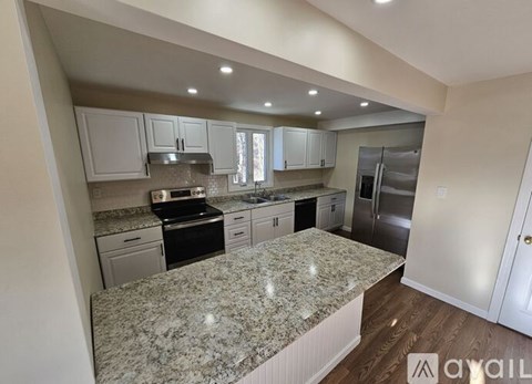 A kitchen with granite countertops and stainless steel appliances.