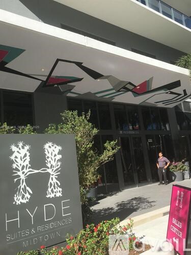 A sign for Hyde Suites & Residences in Midtown is displayed in front of a building.