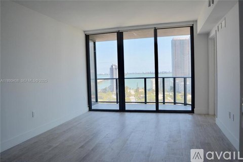 A spacious room with a view of the city through large windows.