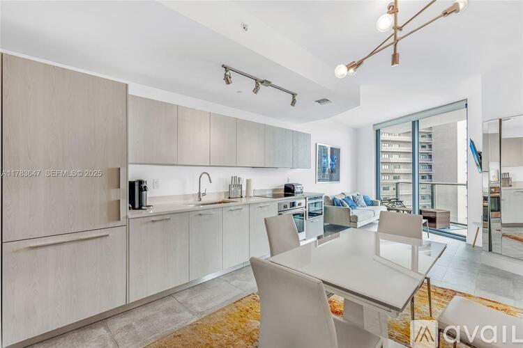 A modern kitchen with a dining table and chairs.