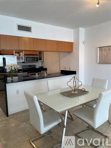 A kitchen with a table and chairs in the foreground.