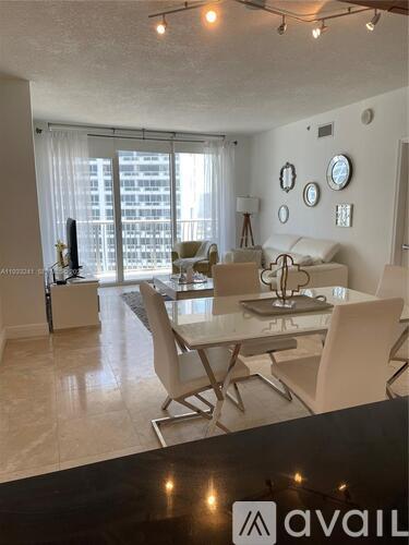 A modern dining room with a glass table and chairs.