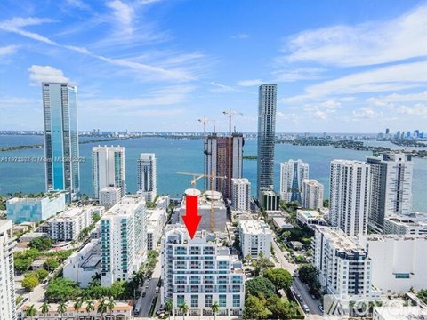 A red arrow points to a building in a cityscape.