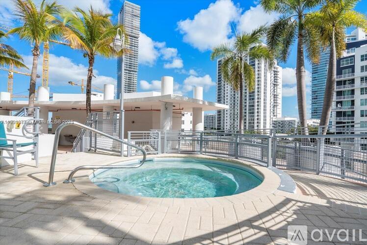 A pool surrounded by palm trees and a city skyline.