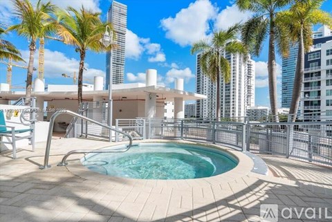 A pool surrounded by palm trees and a city skyline.