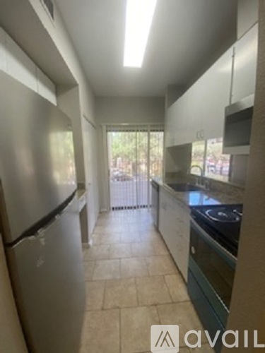 A kitchen with a refrigerator and stove top oven.