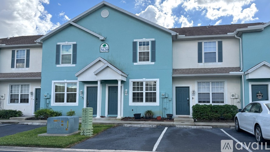 A blue house with a white car parked in front.