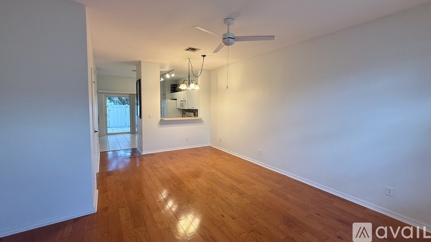 A room with wooden floors and a ceiling fan.