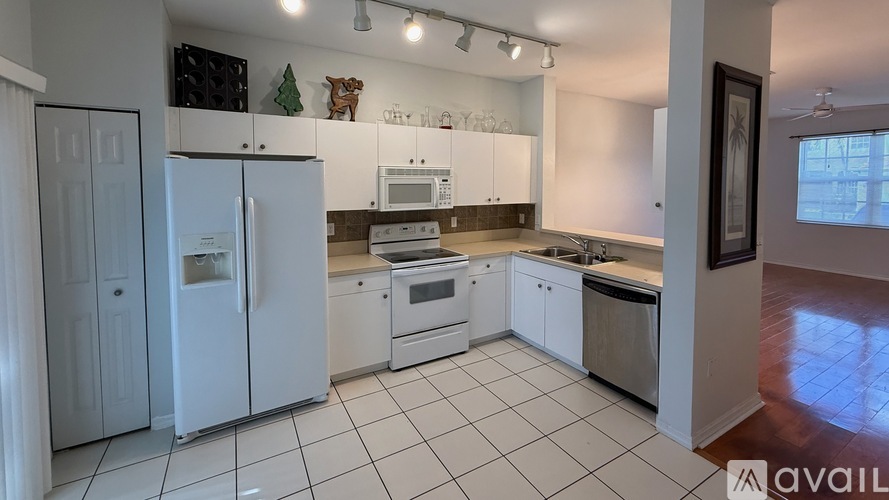 A kitchen with white appliances and cabinets.