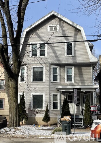 A grey house with a white door and windows.