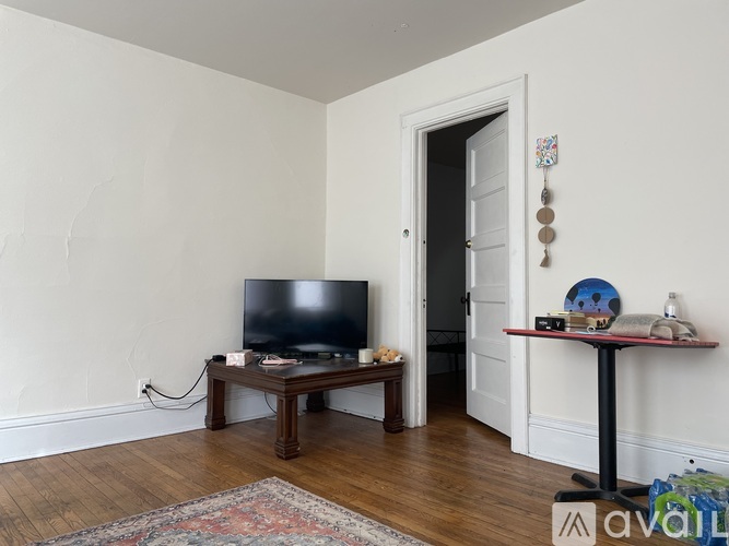 A living room with a television and a rug on the floor.