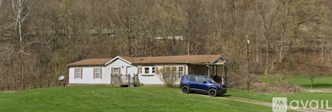 A house with a blue car parked in front.