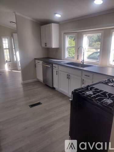 A kitchen with a black stove top oven and white cabinets.