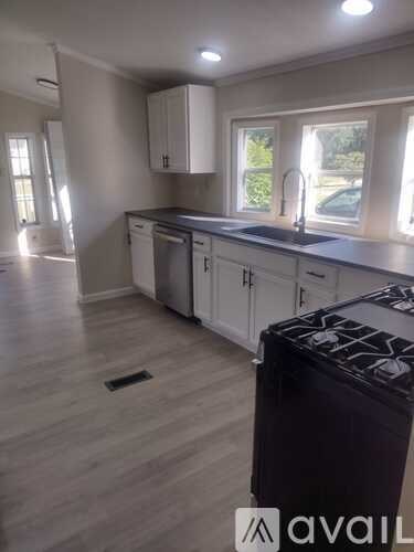 A kitchen with a black stove top oven and white cabinets.