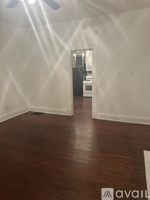 A room with wooden floors and a ceiling fan.