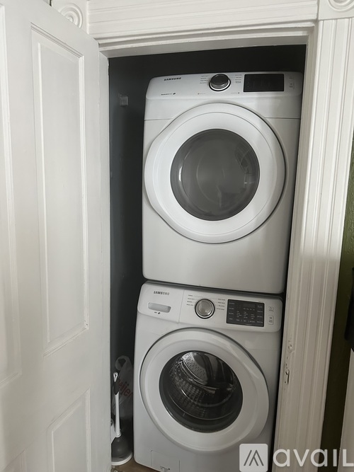 Two white washing machines in a small space.