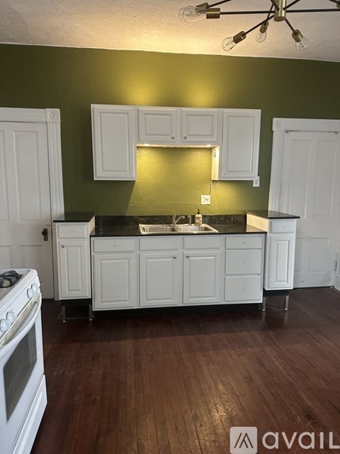 A kitchen with white cabinets and a stove top oven.