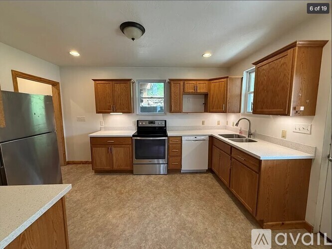 A kitchen with wooden cabinets and a refrigerator.